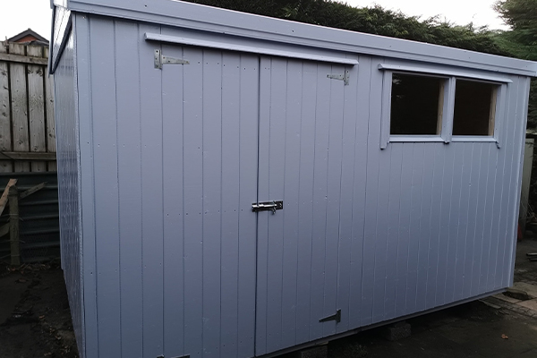 An image of a light blue shed with a window and double doors.