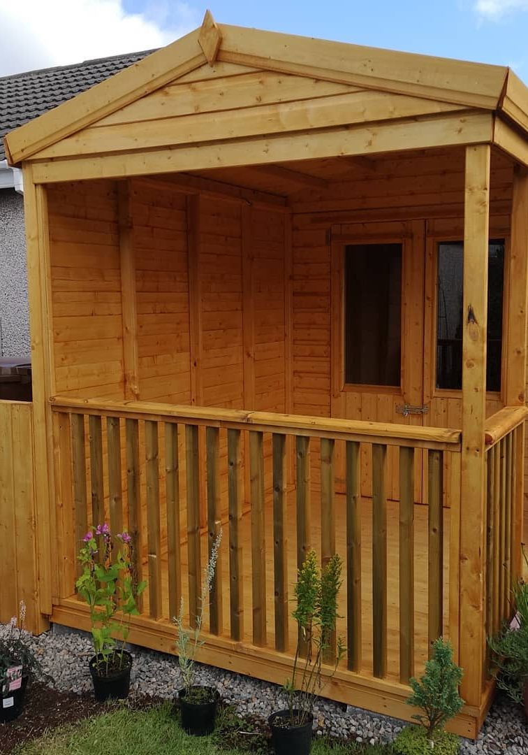 An image of a garden shed with a patio and French doors.